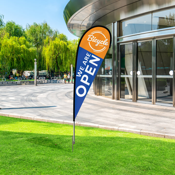Open sign flag in front of a modern building with greenery